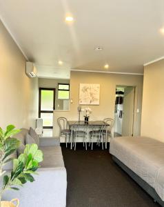 a room with a dining table and a bedroom at Ashbrook Motel Taupo in Taupo