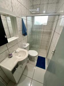 a white bathroom with a sink and a toilet at Apartamento no centro com suíte in Ametista do Sul