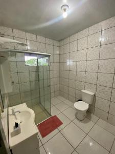 a bathroom with a toilet and a shower and a sink at Apartamento no centro com suíte in Ametista do Sul