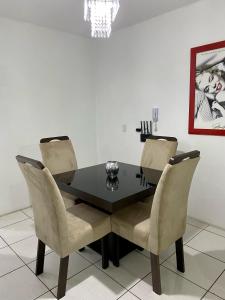 a dining room with a black table and chairs at Apartamento no centro com suíte in Ametista do Sul