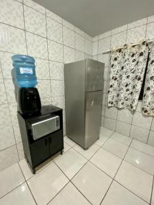 a kitchen with a refrigerator and a water cooler at Apartamento no centro com suíte in Ametista do Sul