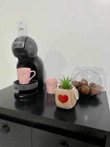 a coffee maker and a plant on a counter at Apartamento no centro com suíte in Ametista do Sul