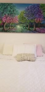une photo d'un lit avec une peinture d'arbres dans l'établissement Robles12 El Cable Luxury Highrise, à Manizales