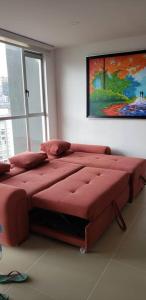 Una gran cama roja en una habitación con una pintura en Robles12 El Cable Luxury Highrise en Manizales