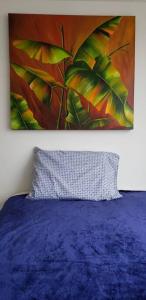 a bedroom with a blue bed and a painting on the wall at Robles12 El Cable Luxury Highrise in Manizales