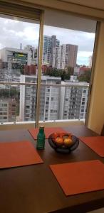 a bowl of fruit on a table in front of a window at Robles12 El Cable Luxury Highrise in Manizales