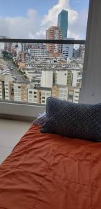 a bedroom with a view of a city from a window at Robles12 El Cable Luxury Highrise in Manizales