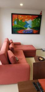 uma sala de estar com um sofá vermelho e uma pintura na parede em Robles12 El Cable Luxury Highrise em Manizales
