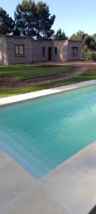 una grande piscina di acqua blu di fronte a una casa di NEco apartamentos Naturistas Nudistas Parejas o mujeres solas a Punta del Este