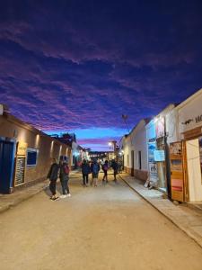 een groep mensen die 's nachts over straat lopen bij Maktub Lodge - San Pedro de Atacama in San Pedro de Atacama