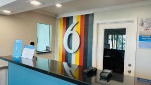 un vestíbulo de oficina con un gran cartel en la pared en Studio 6 Suites San Ysidro CA San Diego South Bay, en San Ysidro