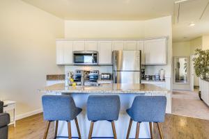 una cocina con armarios blancos y taburetes azules en Portland Apartment about 1 Mi to Downtown! en Portland