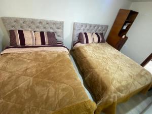 Duas camas sentadas uma ao lado da outra num quarto em Departamento Enorme Centro Histórico ecualodge9 em Cuenca
