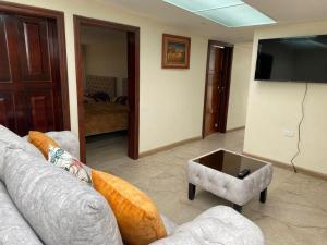 uma sala de estar com um sofá e uma televisão de ecrã plano em Departamento Enorme Centro Histórico ecualodge9 em Cuenca