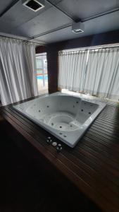 a large bath tub in a room with curtains at Harbour Studio in the WTC BA in Buenos Aires