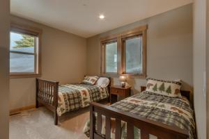 a bedroom with two beds and two windows at Four Seasons at Tahoe Donner - Gorgeous 4 BR Private Hot Tub- Pool Table- Amenity Access in Truckee +27 photos