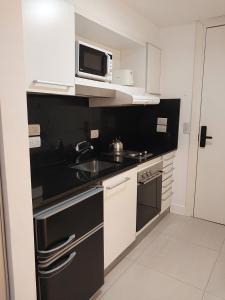 a small kitchen with a sink and a microwave at Harbour Studio in the WTC BA in Buenos Aires