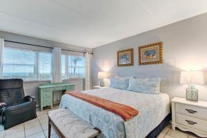 a bedroom with a bed and a chair and a desk at Amelia By The Sea 110 in Fernandina Beach