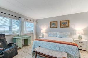 a bedroom with a bed and a chair and a desk at Amelia By The Sea 110 in Fernandina Beach