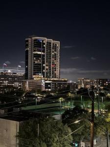 una ciudad por la noche con edificios altos y luces de la calle en Midtown Getaway en Houston