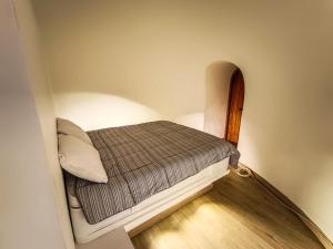 Santa SofíaにあるCasa Iglúのウッドフロアの小さな部屋の小さなベッド1台分です。