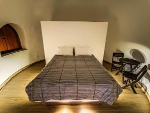 a bed in a room with two chairs and a table at Casa Iglú in Santa Sofía