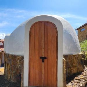 a small dome house with a wooden door at Casa Iglú in Santa Sofía