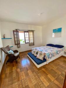 a bedroom with a bed and a chair in it at Casa Egípcia em Morro branco - na quadra da praia in Morro Branco
