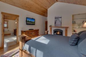 1 dormitorio con 1 cama y chimenea en Majestic Woods at Tahoe Donner - High End Craftsman w Game Room, Hot Tub, Amenity Access, en Truckee