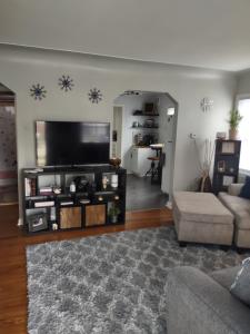 a living room with a large flat screen tv at Roseville Retreat in Roseville