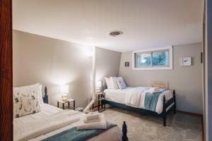 1 dormitorio con 2 camas y ventana en Waterfront Retreat w OG Shuffleboard Dock Kayaks Views, en Kilmarnock