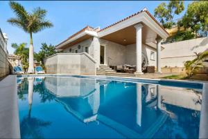 ein Haus mit einem Pool vor einem Haus in der Unterkunft Villa Playa la Arena Beach 12 Pers in Puerto de Santiago