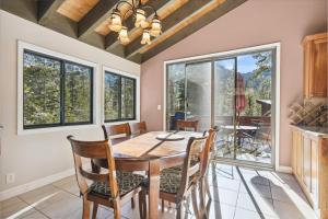 a dining room with a table and chairs and windows at On the Edge at Alpine Meadows - Fireplace- Mountain Views- Great Location! Shuttle Service! in Olympic Valley
