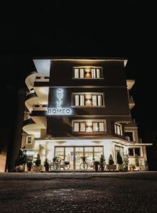 a building with a sign on it at night at Hotel Romeo in Korçë
