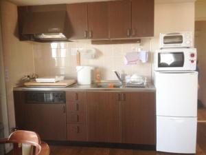 una cucina con lavandino e forno a microonde di Fuji Gotemba Condominium Tannpopo a Gotemba