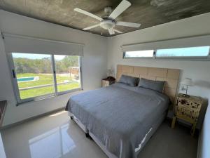 a bedroom with a bed and a ceiling fan at Tranquilidad, playa y naturaleza in José Ignacio