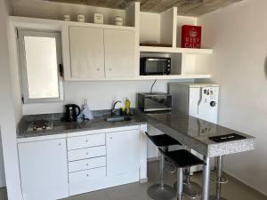 a kitchen with white cabinets and a granite counter top at Tranquilidad, playa y naturaleza in José Ignacio