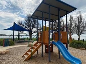 a playground with a slide and a blue slideintend at Spacious Unit in Convenient Location in Yarrawonga