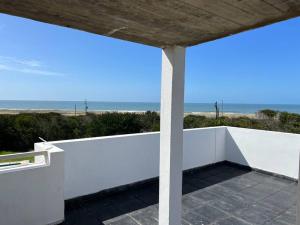 Tranquilidad, playa y naturaleza في خوسيه اجناسيو: شرفة بيضاء مطلة على الشاطئ