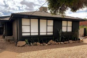 a black house with windows and rocks in front of it at Spacious Unit in Convenient Location in Yarrawonga