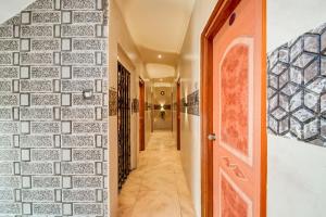 a hallway with a brick wall and a door at Hotel Tejasri Residency in Vijayawāda