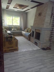 ein Wohnzimmer mit einem Sofa und einem Kamin in der Unterkunft Imouzzer kandar in Imouzzer du Kandar