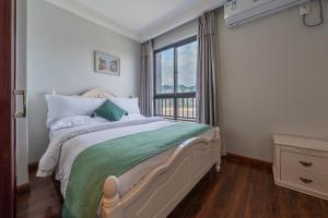 1 dormitorio con cama y ventana grande en Yue Ke Apartment - Changbin Road Branch, en Chongqing