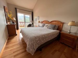 a bedroom with a bed and a large window at Cozy 2 bedrooms condo with stunning Mont Tremblant mountain and lakeview in Mont-Tremblant
