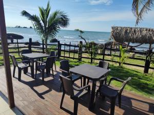 une terrasse avec des tables et des chaises et l'océan dans l'établissement La casa del mar, à San Bernardo del Viento