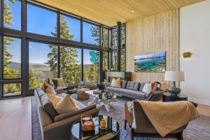 sala de estar con muebles y ventanas grandes. en Soaring Peak at Northstar- Endless Views at this Deluxe Ski-in Ski-out Northstar Residence en Truckee