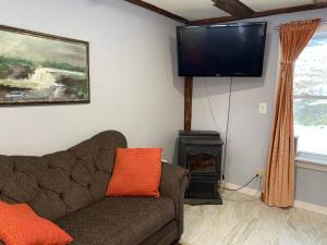 a living room with a couch and a flat screen tv at The Apartment at Sky Hollow in Rochester +32 photos
