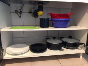 estante de cocina con ollas, sartenes y platos en APARTAMENTO VIAJERO 2 en Buenos Aires