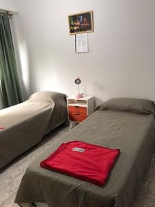 1 dormitorio con 2 camas y 1 toalla roja en la cama en APARTAMENTO VIAJERO 2 en Buenos Aires