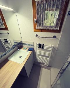 a small bathroom with a sink and a mirror at Appartement 6-8 personnes à 3 minutes des pistes in Peisey-Nancroix